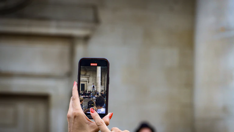 A person records a live performance with a smartphone camera