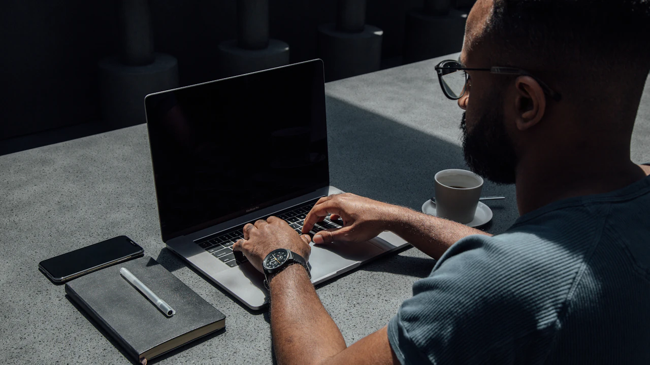 A marketer writes creator outreach on a laptop at an outdoor workspace