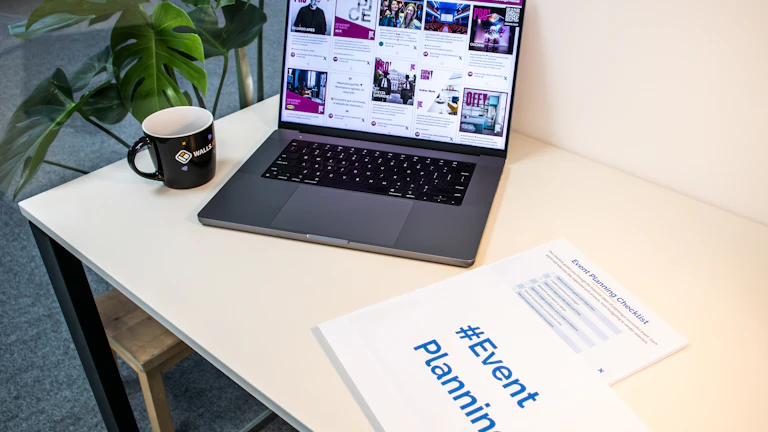 A laptop and printed checklist arranged for reviewing creator profiles