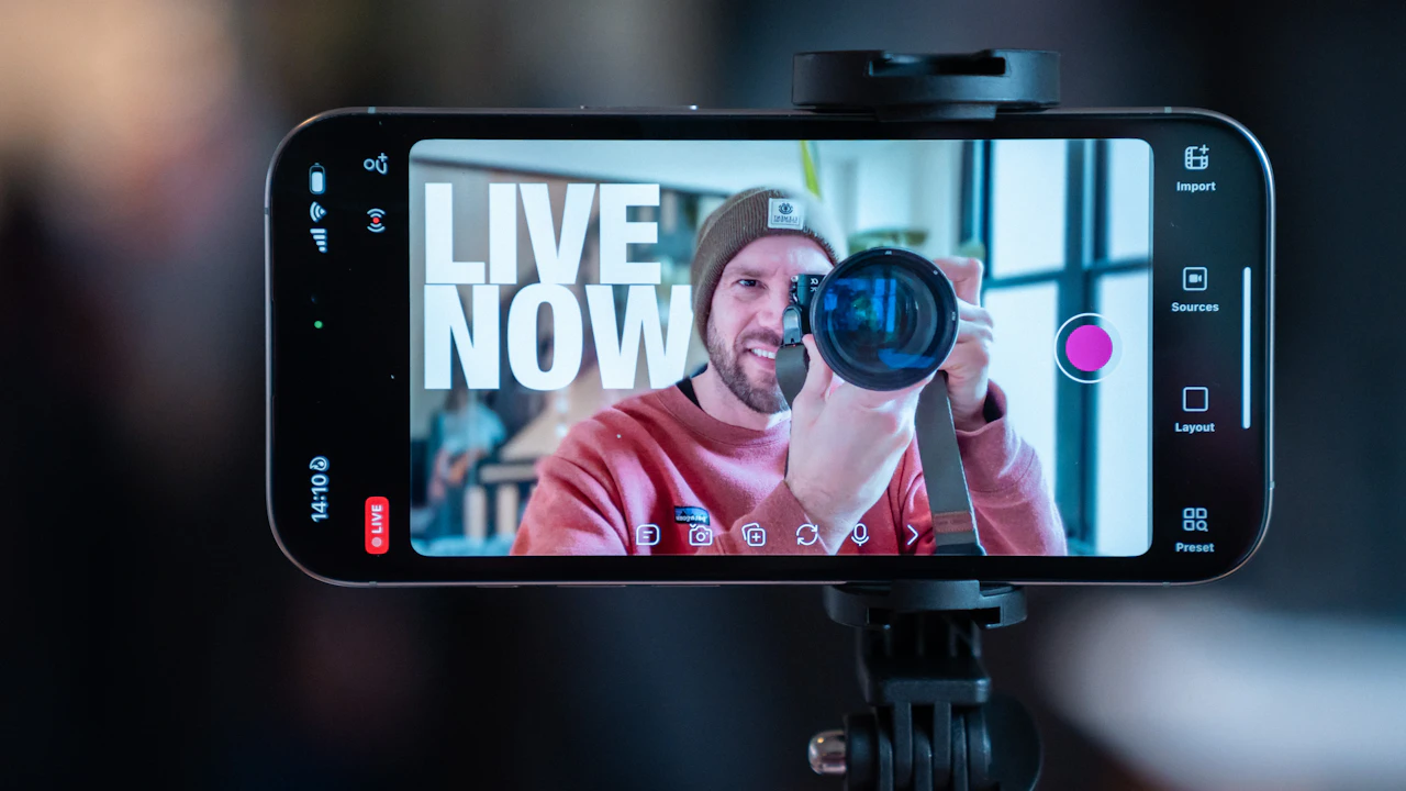 A creator films himself with a camera through a smartphone on a tripod